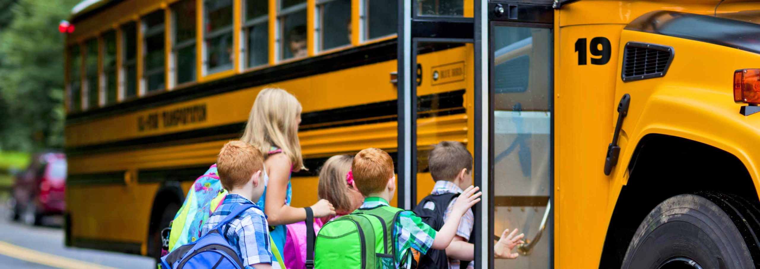 children getting on school bus