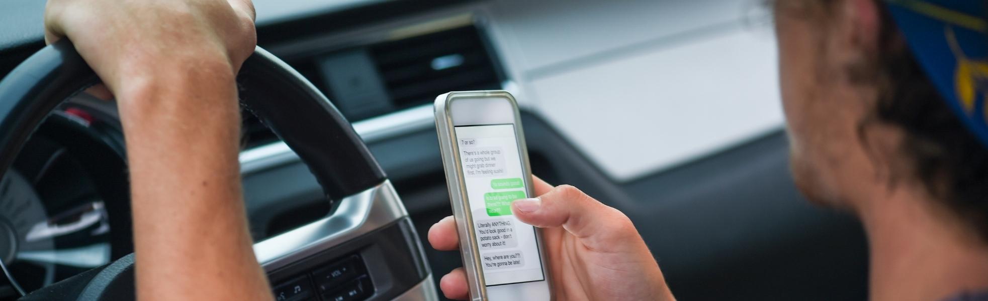 Man driving with a phone on his hand