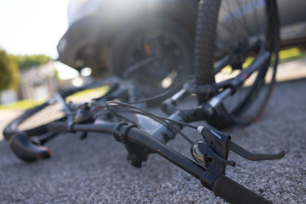 Close-up of a damaged bicycle lying on the road after a crash