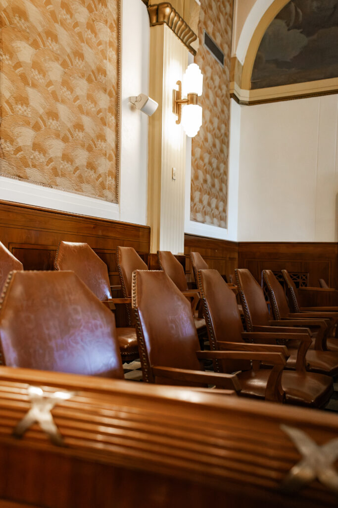Empty wooden jury chairs in a courtroom with warm lighting and classic decor, representing the legal process and justice system.
